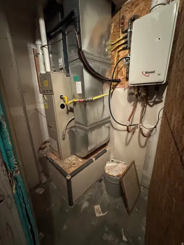 Furnace and wall-mounted tankless water heater with exposed ductwork and utility lines