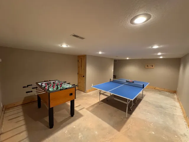 Spacious lower level room featuring recessed lighting and a natural wood-finish door