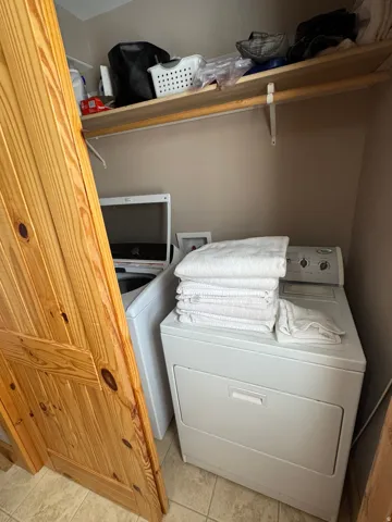 Dedicated laundry area featuring a white top-load washing machine and a white front-load dryer
