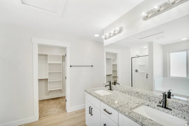 Photos are of a previously built home of the same floor plan. Finishes, colors, features, and upgrades may vary. Dual vanity with granite countertops, undermount sinks, and matte black fixtures