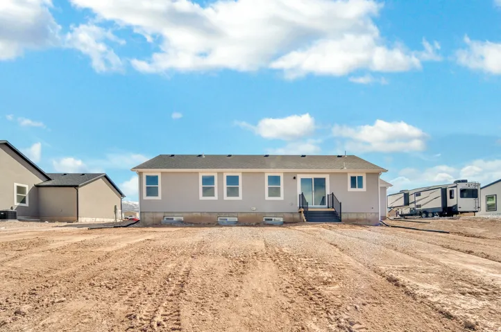 Photos are of a previously built home of the same floor plan. Finishes, colors, features, and upgrades may vary. Rear exterior featuring light gray siding, white window trim, a sliding glass door with a dark railing, and a dark shingled roof