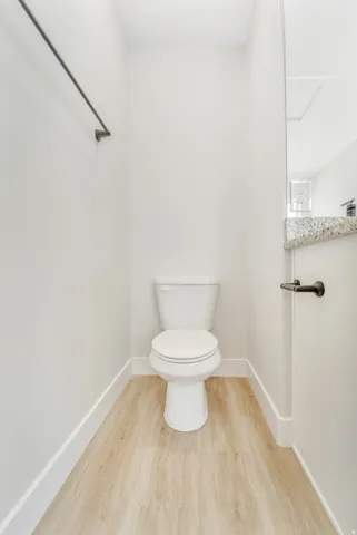 Photos are of a previously built home of the same floor plan. Finishes, colors, features, and upgrades may vary. Bathroom featuring a white toilet, wood-finish flooring, white baseboards, and a towel bar