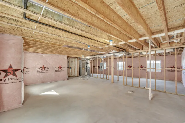 Photos are of a previously built home of the same floor plan. Finishes, colors, features, and upgrades may vary. Unfinished basement with exposed wooden joists and subflooring, insulated walls, concrete flooring, and partial framing
