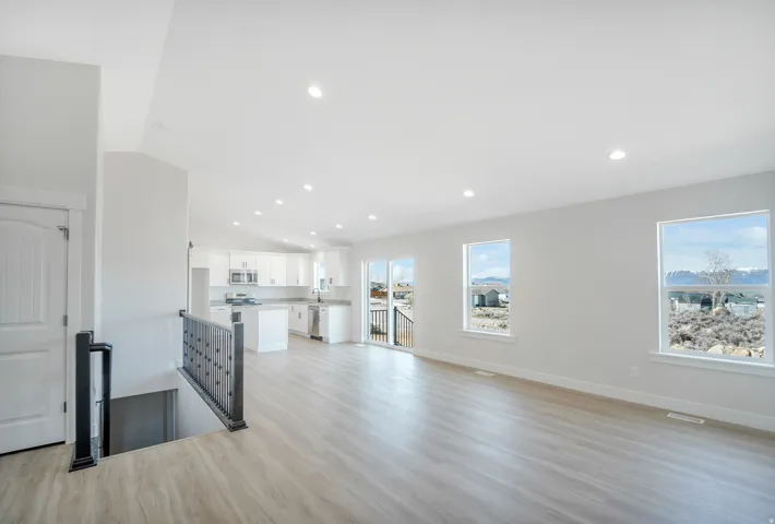 Photos are of a previously built home of the same floor plan. Finishes, colors, features, and upgrades may vary. Open concept living area featuring wood-finish flooring and recessed lighting