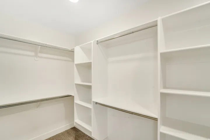 Photos are of a previously built home of the same floor plan. Finishes, colors, features, and upgrades may vary. Walk-in closet featuring white built-in shelving, multiple hanging rods, and recessed lighting