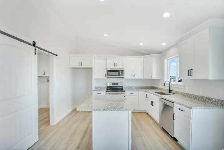 Photos are of a previously built home of the same floor plan. Finishes, colors, features, and upgrades may vary. Modern kitchen with white cabinetry and light-toned wood-finish flooring