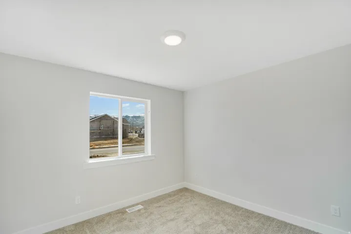 Photos are of a previously built home of the same floor plan. Finishes, colors, features, and upgrades may vary. Neutral-toned room featuring a double-pane window, recessed ceiling light, white baseboards, and carpeted flooring