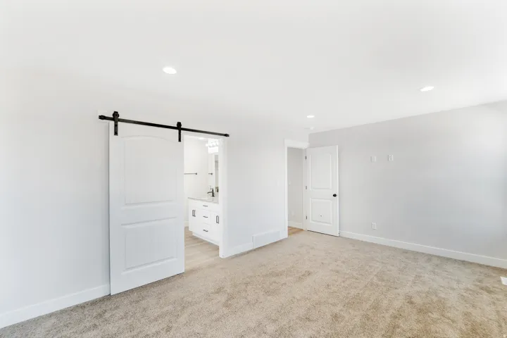 Photos are of a previously built home of the same floor plan. Finishes, colors, features, and upgrades may vary. Spacious room featuring neutral carpeting, recessed lighting, and a white barn door