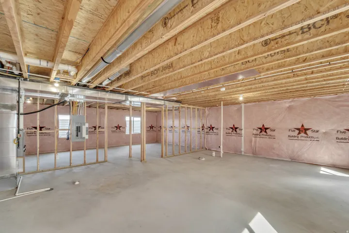 Photos are of a previously built home of the same floor plan. Finishes, colors, features, and upgrades may vary. Unfinished lower level with wood framing, exposed joists, concrete flooring, and insulated perimeter walls