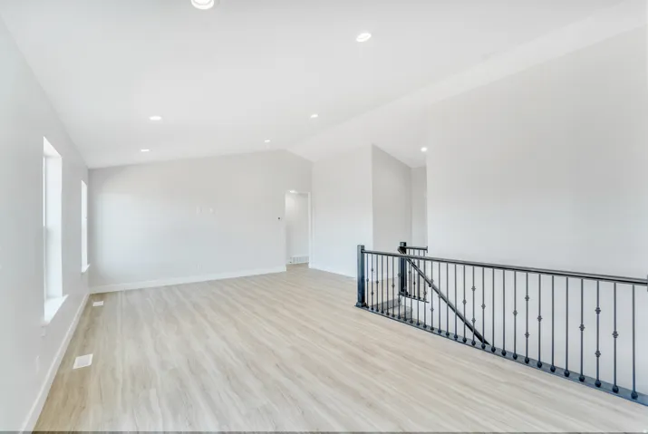 Photos are of a previously built home of the same floor plan. Finishes, colors, features, and upgrades may vary. Spacious interior featuring wood-finish flooring, recessed lighting, and a contemporary black iron staircase railing