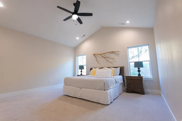 Spacious room featuring vaulted ceilings, recessed lighting, and a ceiling fan