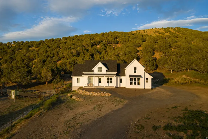 White farmhouse exterior with a black shingle roof