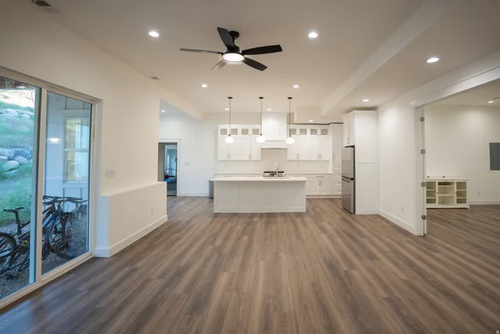 Expansive open-concept living space featuring wood-finish flooring, recessed lighting, and a modern ceiling fan