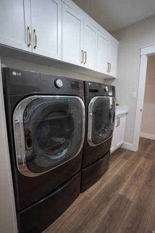 Dedicated laundry area featuring wood-finish flooring