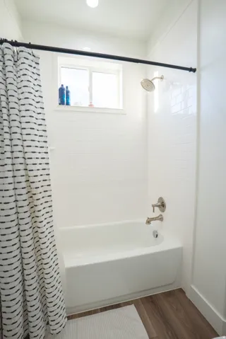 Bathtub with white subway tile surround and brushed nickel fixtures