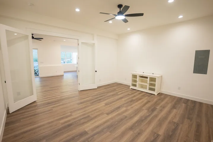 Spacious room featuring wood-finish flooring, recessed lighting, and a contemporary ceiling fan