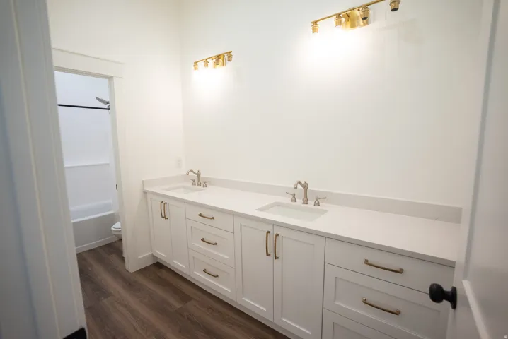 Dual vanity featuring white shaker-style cabinetry, white countertops, and brushed nickel fixtures