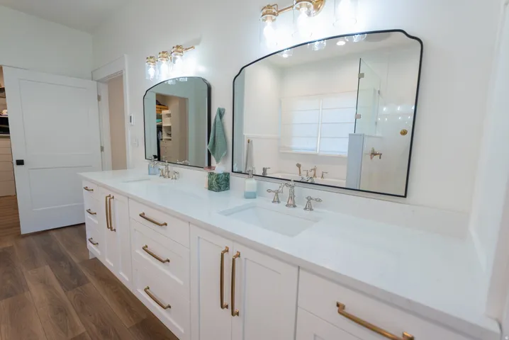 Dual vanity with white cabinetry and gold-tone hardware