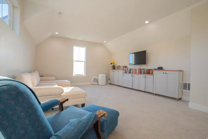 Spacious bonus room featuring vaulted ceilings, recessed lighting, carpet flooring, and multiple windows