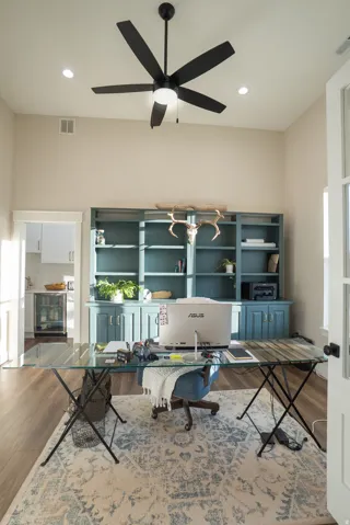 Room featuring a high ceiling with recessed lighting and a black ceiling fan