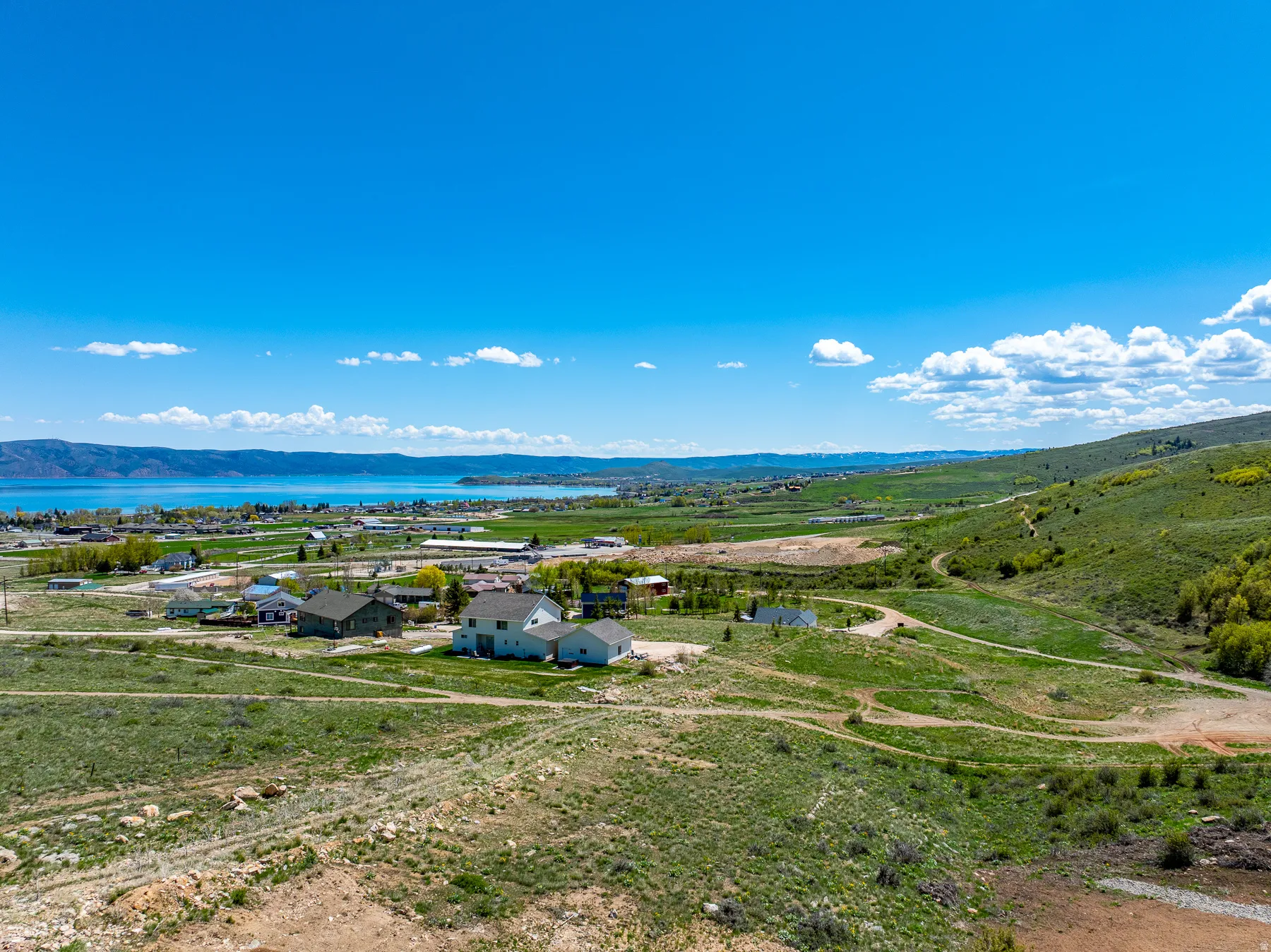 Expansive hillside property featuring a partially graded building site with a gravel access road