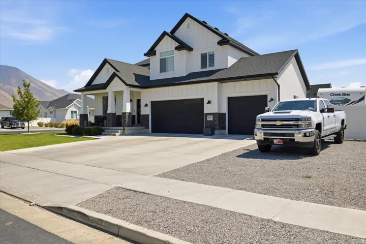 Contemporary-style exterior with black trim, a covered entry, and a two-car garage