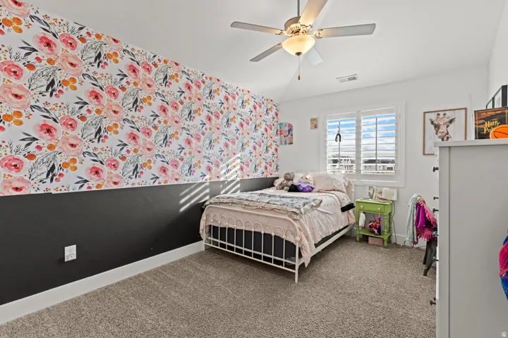 Bedroom featuring a two-tone wall design with floral wallpaper and a solid lower section