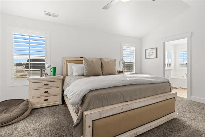 Carpeted bedroom with vaulted ceiling and recessed lighting
