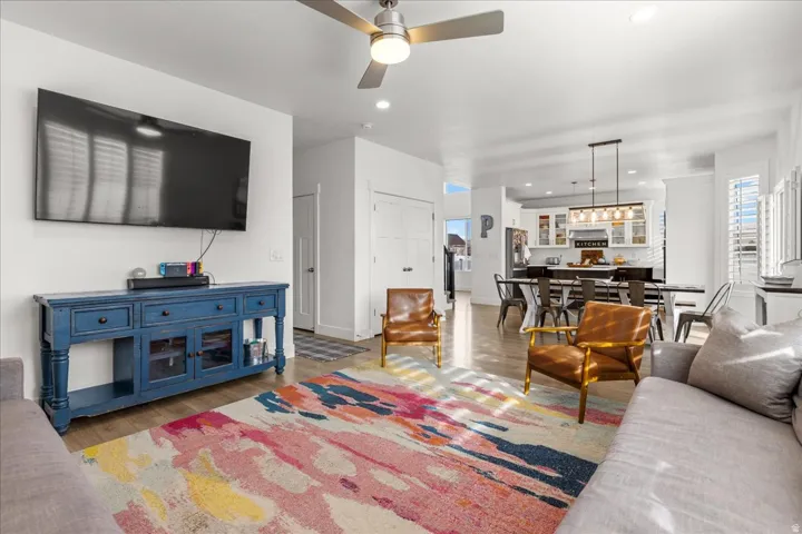 Expansive open-concept living area featuring wood-finish flooring, recessed lighting, and a ceiling fan