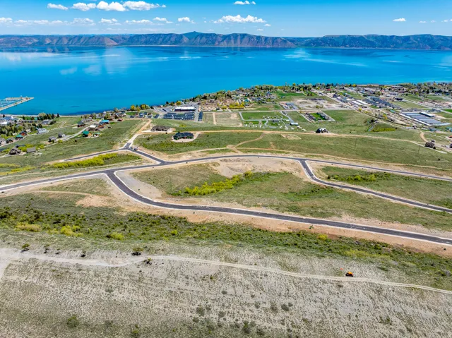 Expansive land parcel with graded roads and utilities, offering lake and mountain backdrop
