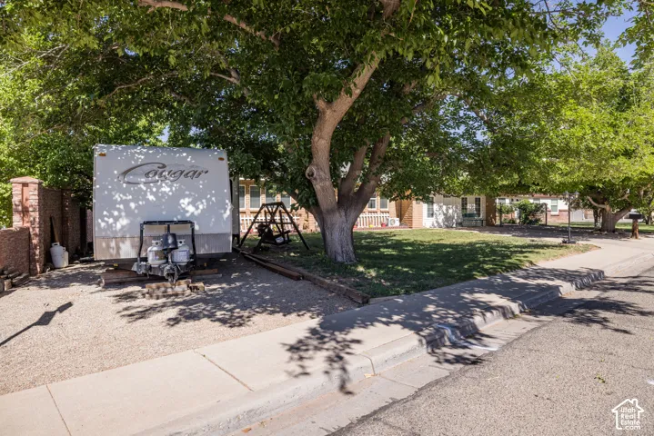 Gravel parking area featuring a brick privacy wall