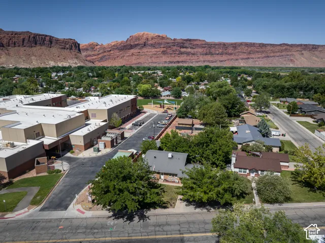 Expansive red rock geological formations provide a dramatic backdrop to the verdant landscape