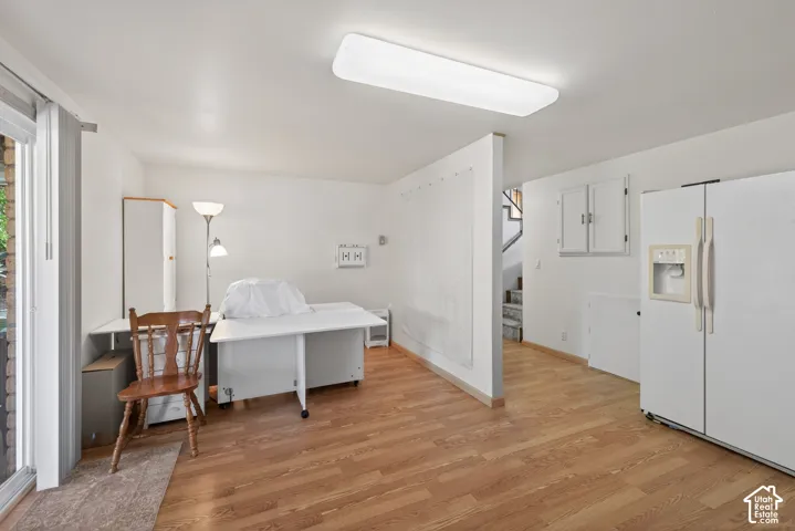 Spacious room featuring wood-finish flooring, white walls, and a recessed ceiling light