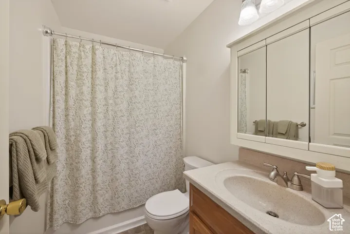 Bathroom featuring a shower-tub combination, single vanity with integrated sink, and triple mirrored medicine cabinet