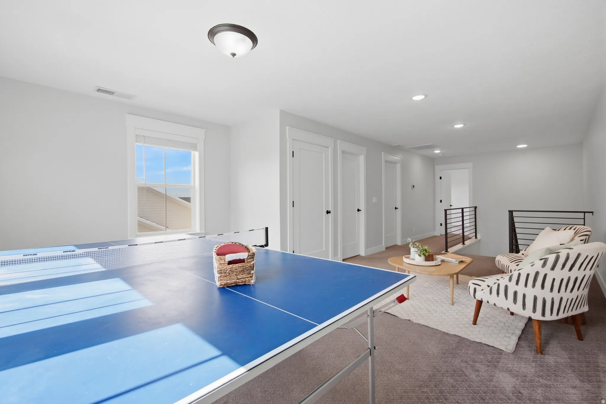 Spacious room featuring carpeting, multiple doors, and an open railing