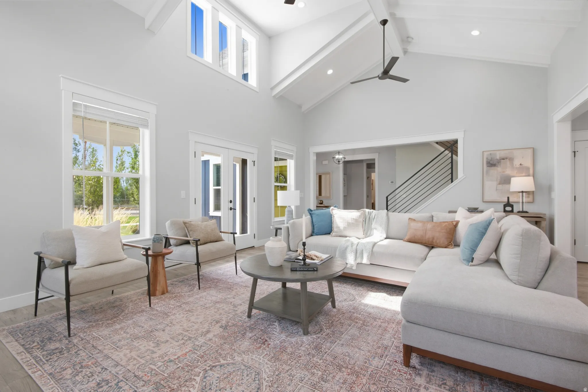 Vaulted ceilings, exposed beams, transom windows, wood-finish flooring, and French doors