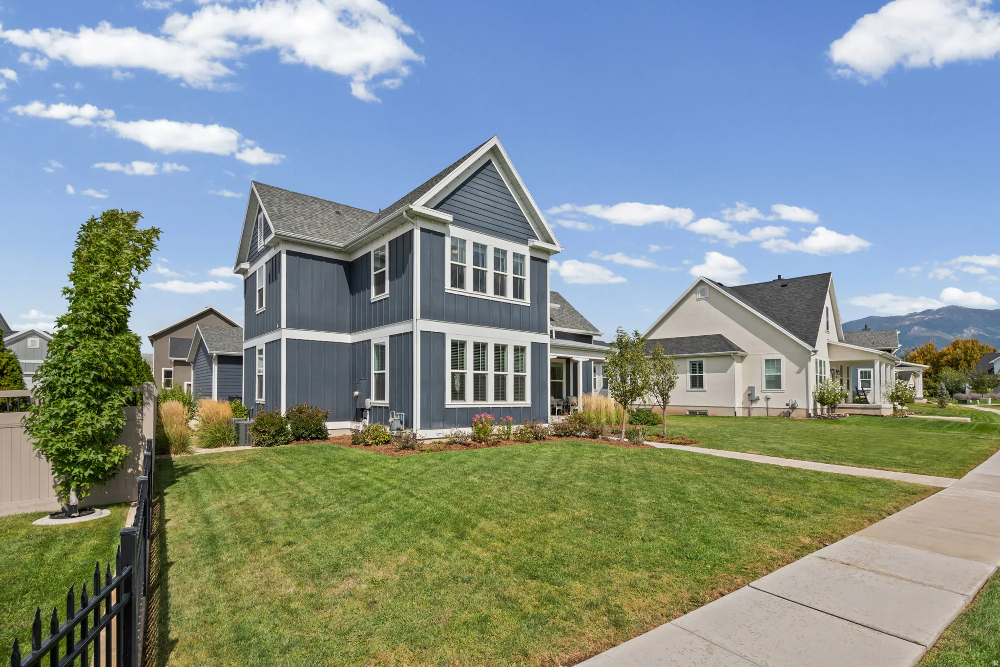 Two-story residence featuring blue siding with white trim and multiple windows