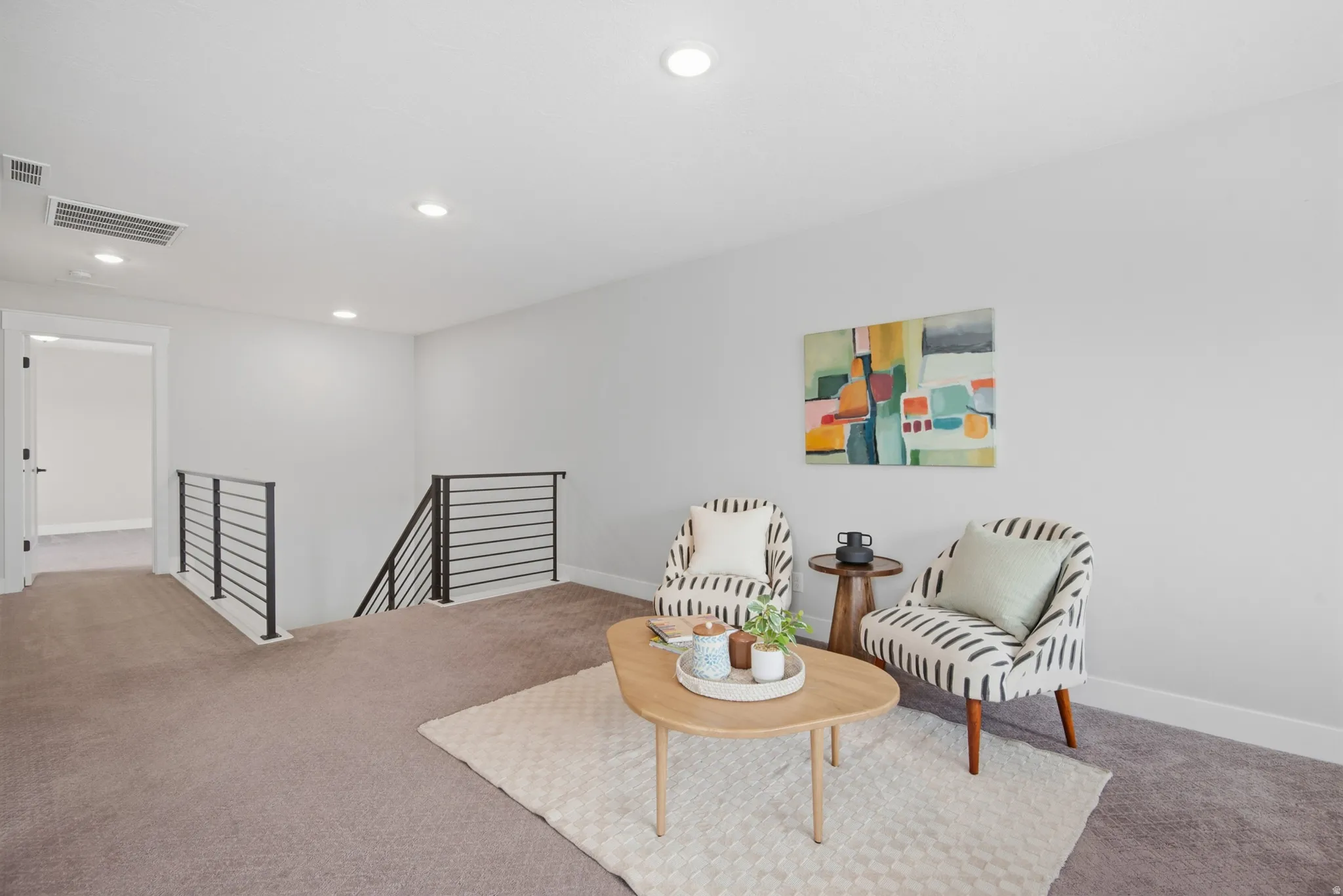 Open loft space with recessed lighting, carpet flooring, and contemporary horizontal metal railings