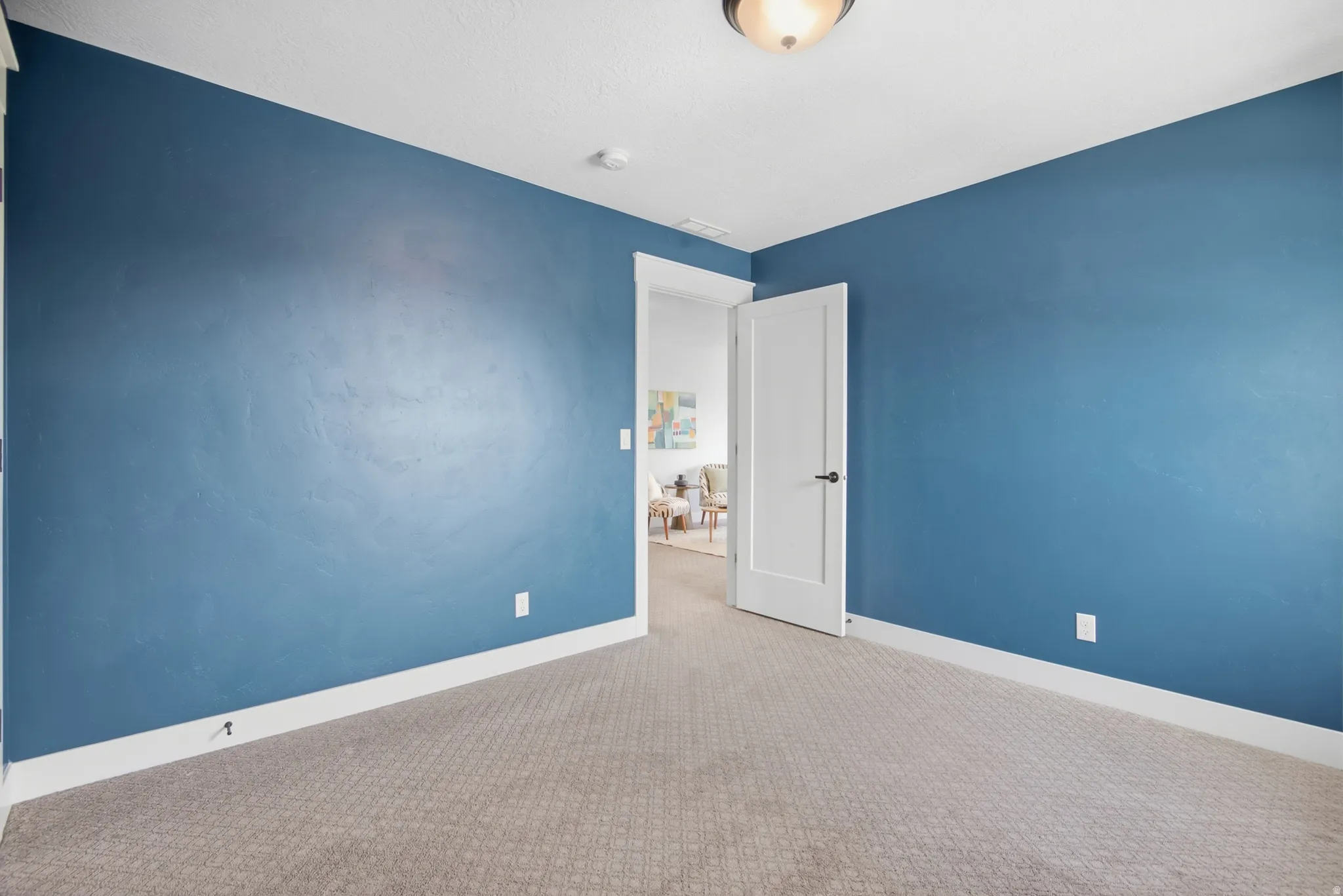 Bedroom 3 Carpeted flooring, blue wall finish, white trim, white interior door, and flush-mount ceiling light