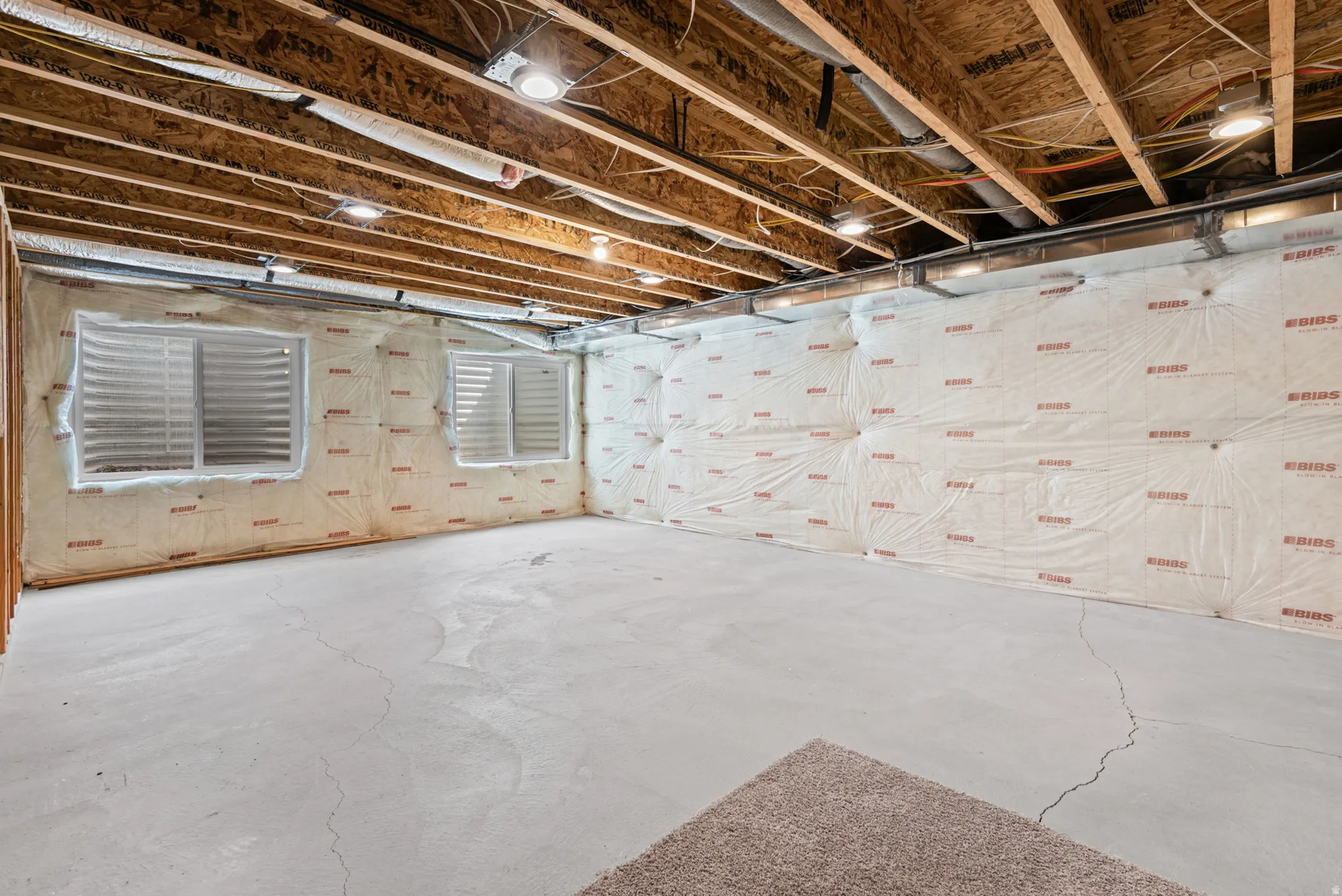 Unfinished basement family room with recessed lighting
