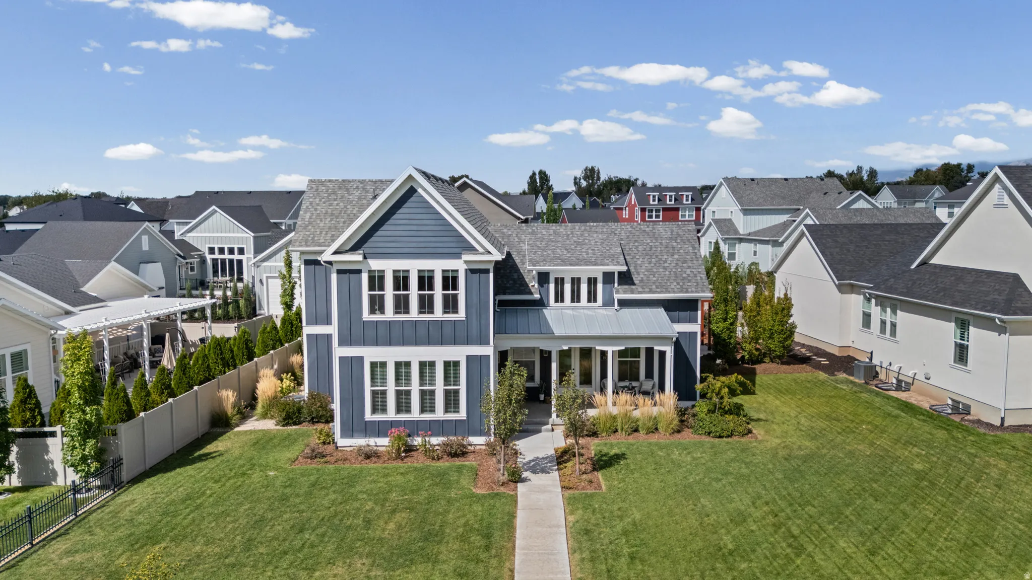 Two-story residence featuring a covered front porch, gabled rooflines, and a paved walkway