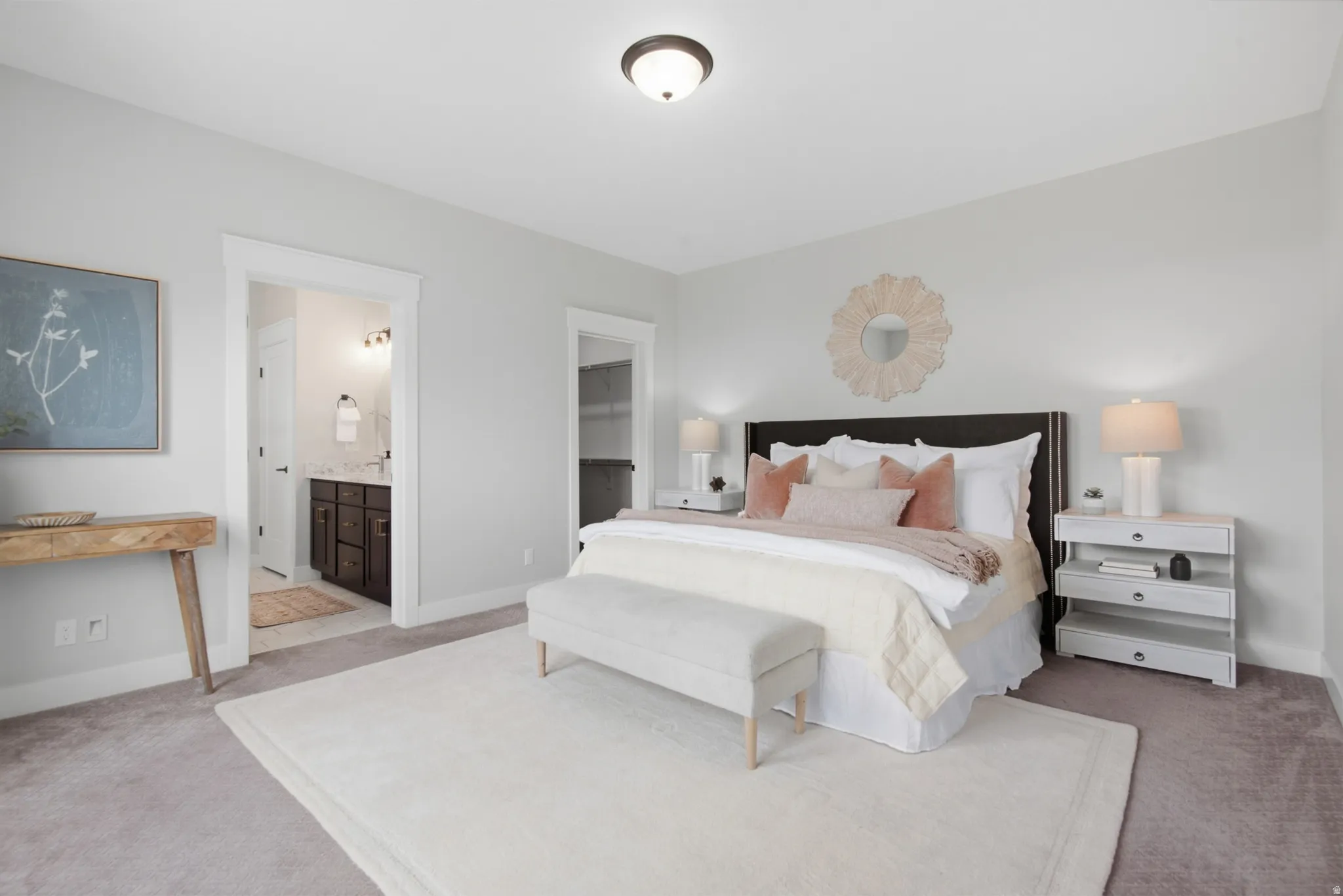 Primary Bedroom. Recessed ceiling lighting illuminates the space, featuring carpet flooring and a king- sized bed with an upholstered headboard