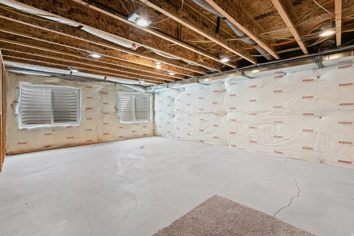 Unfinished basement family room with recessed lighting