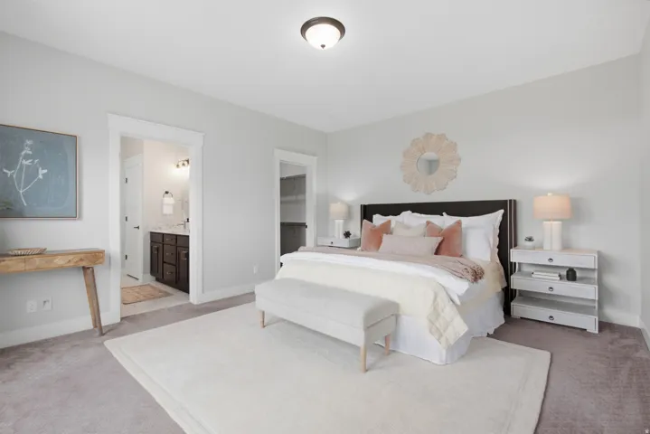 Primary Bedroom. Recessed ceiling lighting illuminates the space, featuring carpet flooring and a king- sized bed with an upholstered headboard