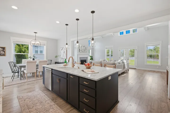 Kitchen island with granite-finish countertop, wood-finish flooring, recessed lighting, high vaulted ceilings, and French doors