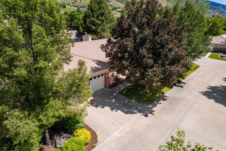 Single-story residence featuring a two-car garage, concrete driveway, and mature landscaping