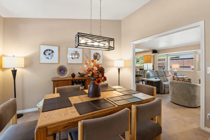 Dining area featuring a wood-finish table with coordinating chairs, an overhead rectangular chandelier, and a built-in wood-finish buffet with integrated storage