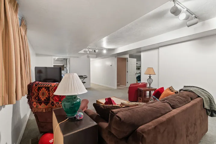 Lower-level living area with recessed track lighting and neutral wall finishes