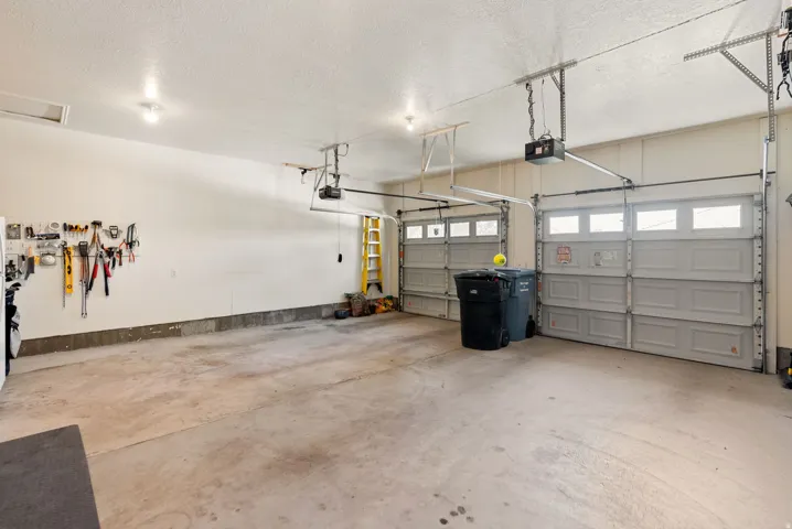 Two-car garage featuring automatic openers and overhead lighting