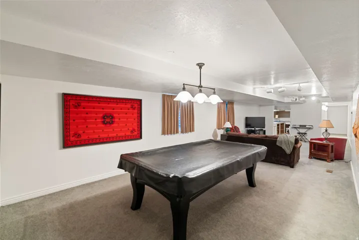 Spacious recreational area featuring carpeted flooring and recessed lighting